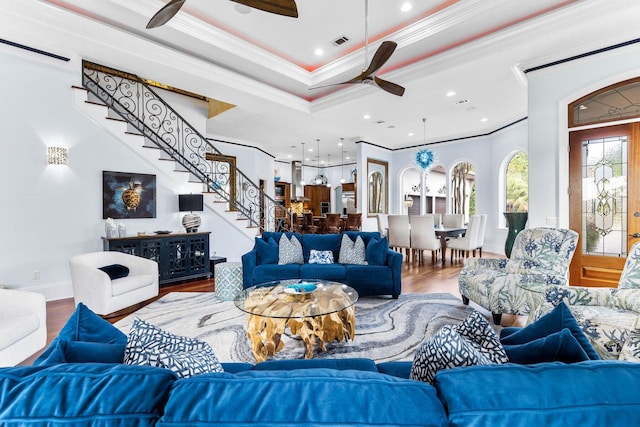 living room featuring ceiling fan, crown molding, a tray ceiling, and hardwood / wood-style floors