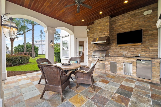 view of patio with an outdoor kitchen, area for grilling, and ceiling fan