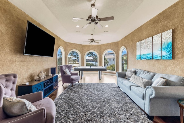 living room featuring a textured ceiling, hardwood / wood-style flooring, and ceiling fan