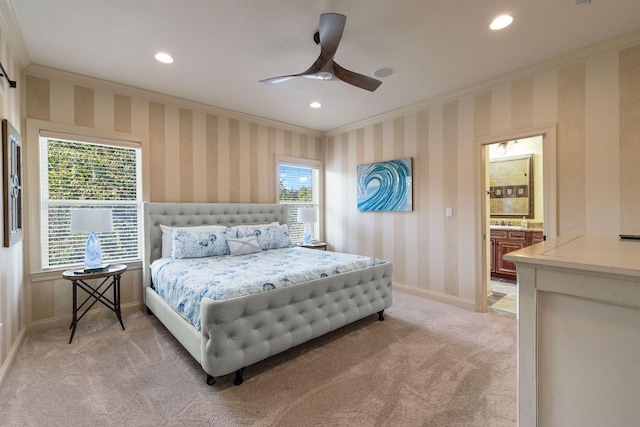 carpeted bedroom featuring ensuite bath, crown molding, and ceiling fan