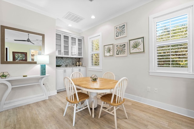 dining room featuring light hardwood / wood-style floors, ornamental molding, and ceiling fan