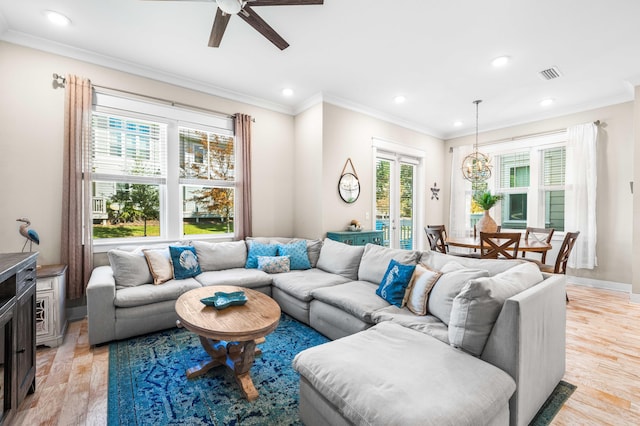 living room with ornamental molding, light hardwood / wood-style floors, and plenty of natural light