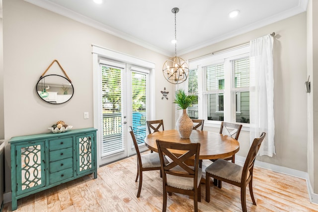 dining space with ornamental molding, a chandelier, and light hardwood / wood-style flooring