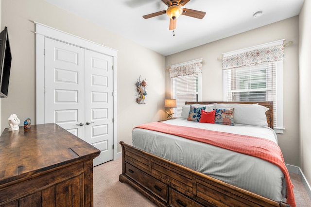 bedroom with a closet, ceiling fan, and light colored carpet