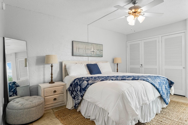 tiled bedroom with a textured ceiling, a closet, and ceiling fan