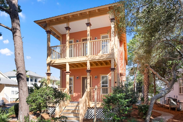 view of front of house featuring cooling unit and a balcony