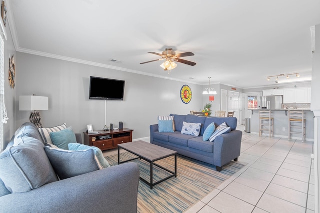 living room with ornamental molding, light tile patterned floors, and ceiling fan with notable chandelier