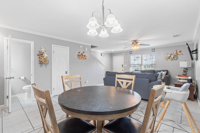 dining area with crown molding, ceiling fan with notable chandelier, and light tile patterned floors