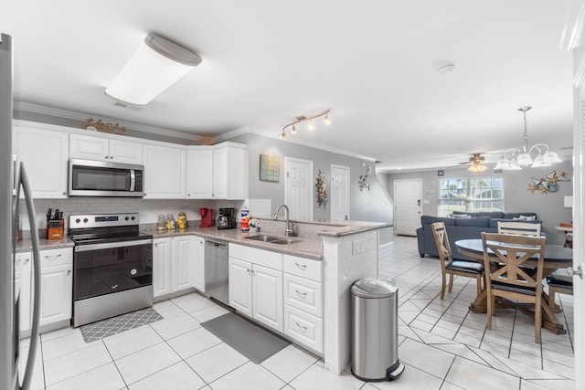 kitchen with kitchen peninsula, appliances with stainless steel finishes, white cabinetry, ornamental molding, and sink