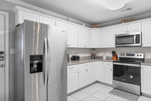 kitchen with white cabinetry, stainless steel appliances, light stone counters, ornamental molding, and light tile patterned floors