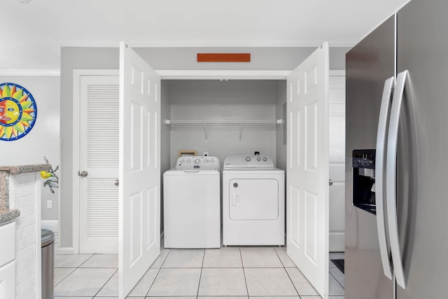 washroom featuring crown molding, light tile patterned flooring, and washing machine and dryer