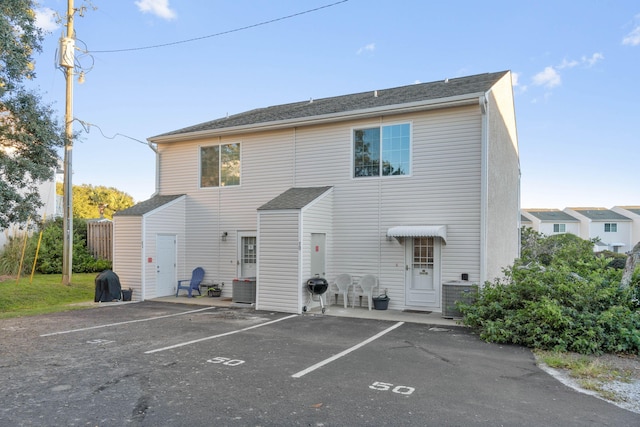 rear view of property with central AC