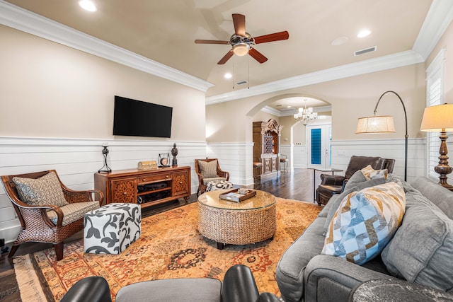 living room featuring crown molding, wood-type flooring, and ceiling fan with notable chandelier