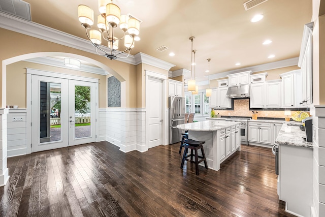 kitchen featuring a healthy amount of sunlight, dark hardwood / wood-style floors, stainless steel appliances, and a kitchen island