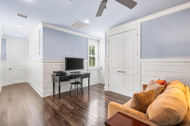 office area with crown molding, wood walls, dark wood-type flooring, and ceiling fan