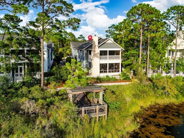 rear view of property featuring a sunroom