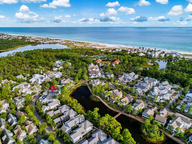 birds eye view of property featuring a water view and a beach view