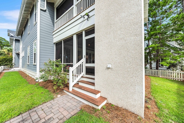 property entrance featuring a yard and a balcony