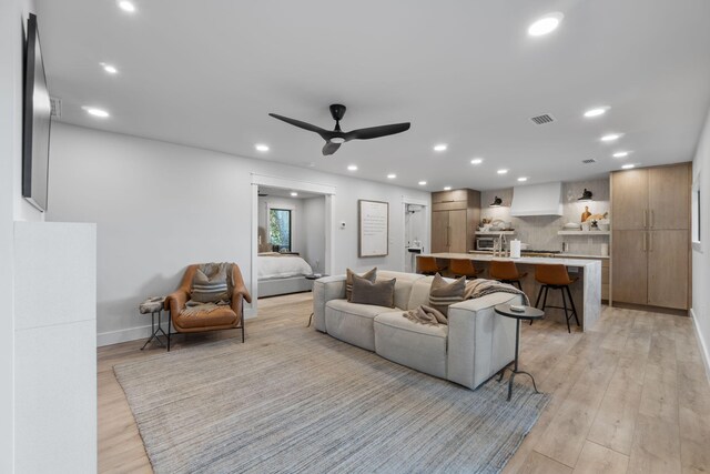 living room featuring ceiling fan and light hardwood / wood-style flooring