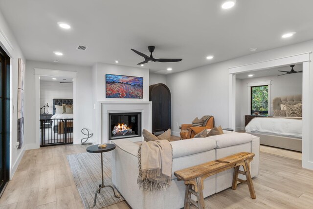 living room with ceiling fan and light wood-type flooring