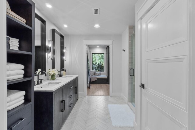 bathroom featuring parquet flooring, vanity, and an enclosed shower