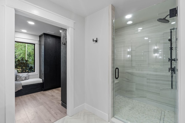 bathroom with hardwood / wood-style floors and a shower with shower door