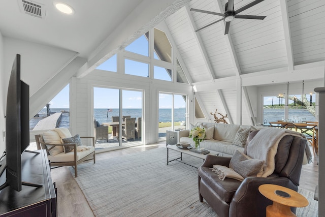living room with ceiling fan, a water view, light hardwood / wood-style floors, and plenty of natural light