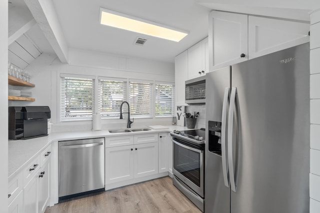 kitchen featuring a healthy amount of sunlight, sink, white cabinetry, and appliances with stainless steel finishes