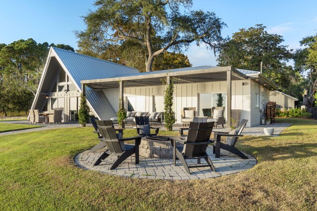rear view of property with an outdoor fire pit, a patio, and a yard