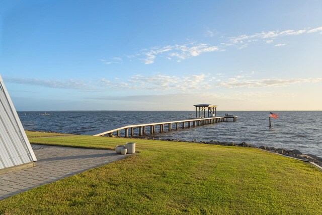 dock area with a water view and a yard