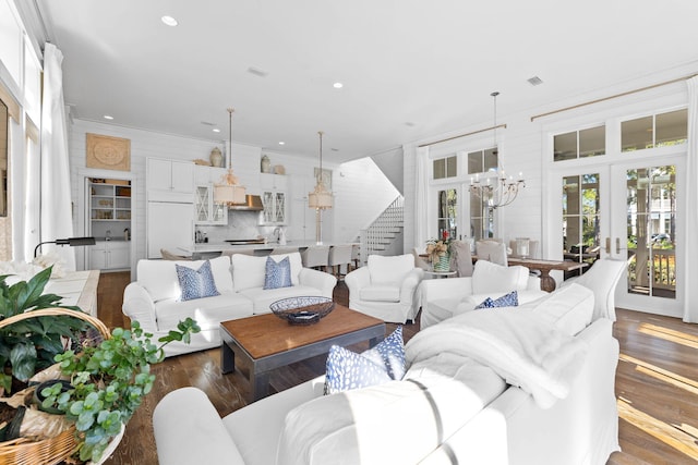 living room with french doors, ornamental molding, sink, an inviting chandelier, and dark hardwood / wood-style floors