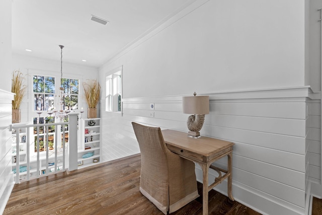 dining area featuring hardwood / wood-style floors, crown molding, and a chandelier