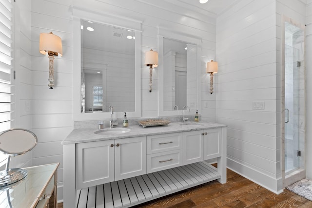 bathroom with wood-type flooring, vanity, and a shower with shower door