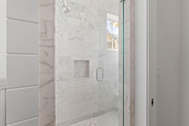 bathroom with a shower with door