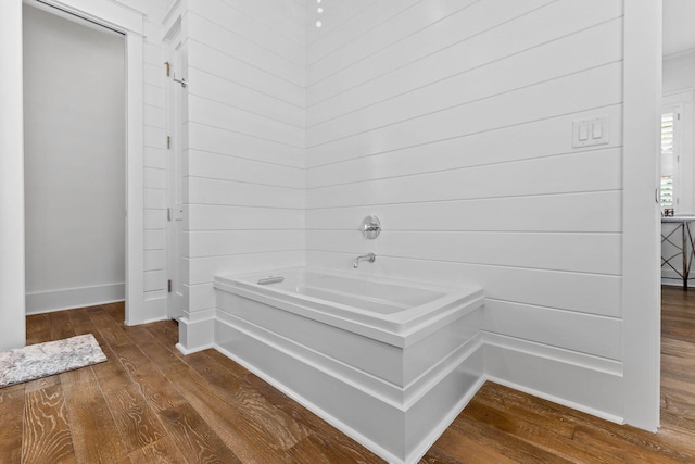 bathroom with a washtub and hardwood / wood-style flooring