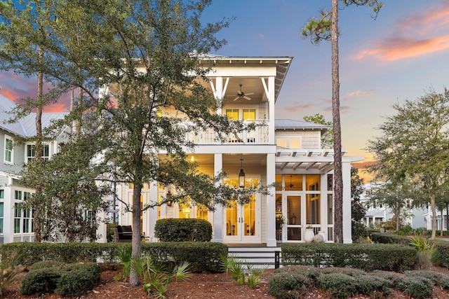 view of front facade featuring ceiling fan, a balcony, and french doors