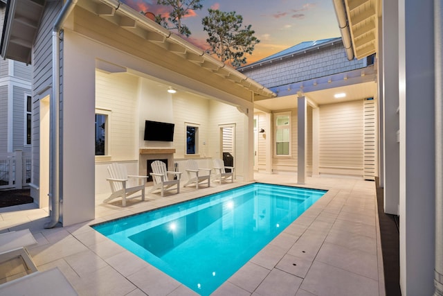 view of pool featuring a patio and an outdoor fireplace