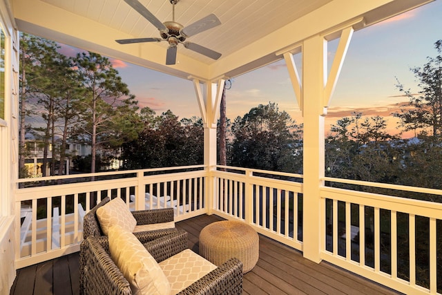 deck at dusk featuring ceiling fan and an outdoor hangout area