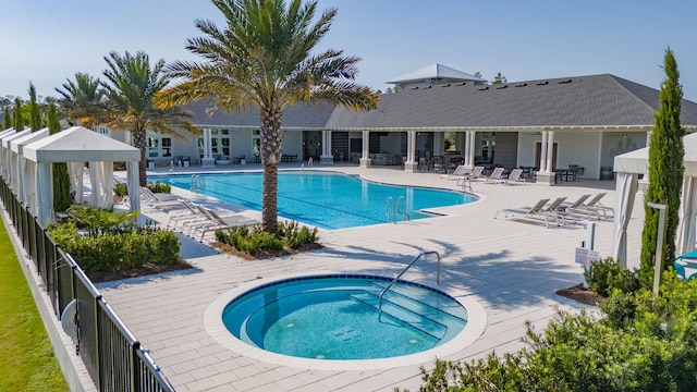 view of pool featuring a hot tub and a patio