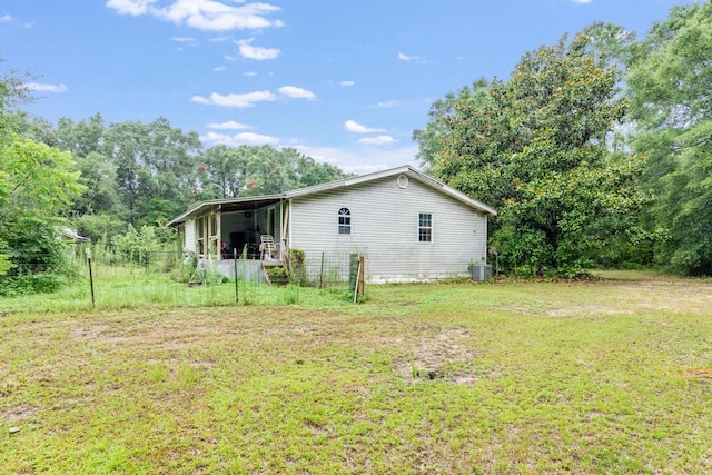 view of side of property featuring central air condition unit and a yard