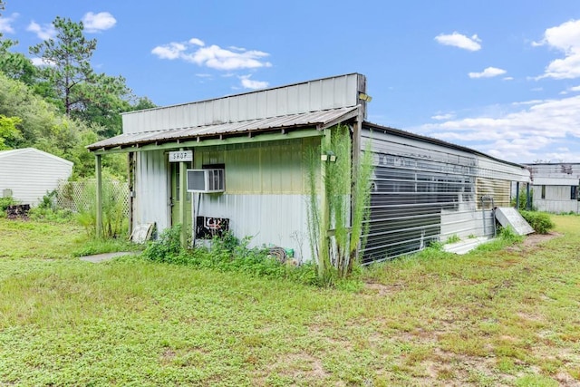 view of outdoor structure with a yard and a wall unit AC