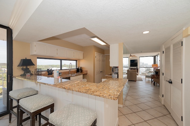 kitchen with a breakfast bar area, kitchen peninsula, and a healthy amount of sunlight