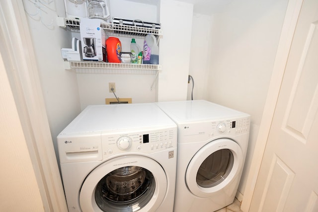 laundry area featuring washer and clothes dryer and tile patterned flooring