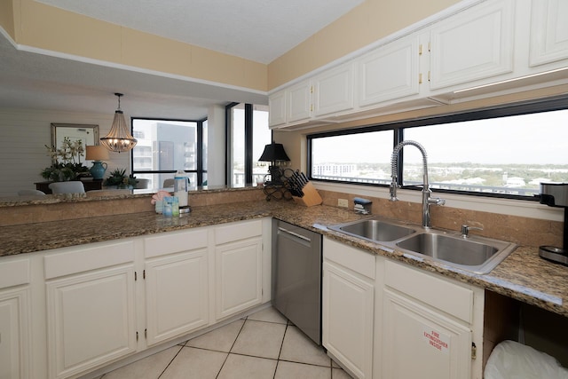 kitchen with decorative light fixtures, stainless steel dishwasher, a sink, light tile patterned floors, and white cabinetry
