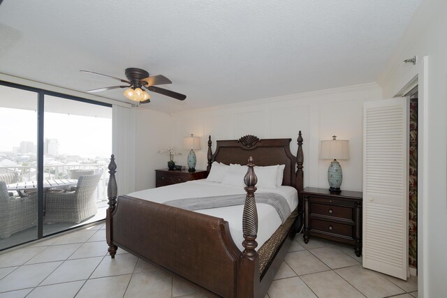 bedroom featuring a ceiling fan, light tile patterned floors, and access to exterior