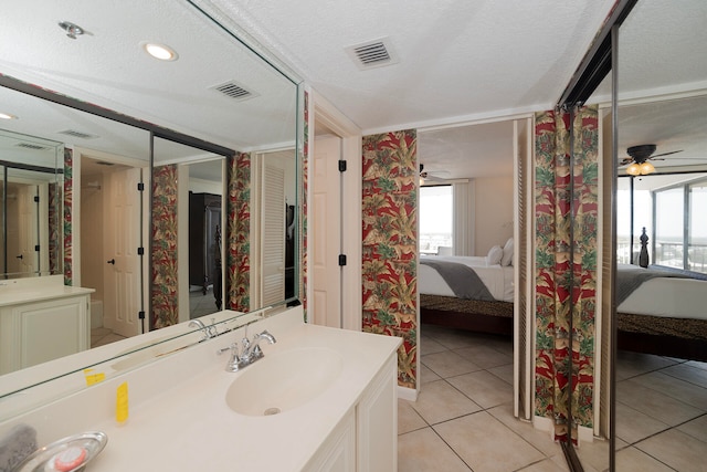 bathroom with vanity, ceiling fan, a textured ceiling, and tile patterned floors