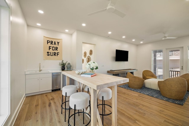 dining room with sink, light hardwood / wood-style floors, and ceiling fan