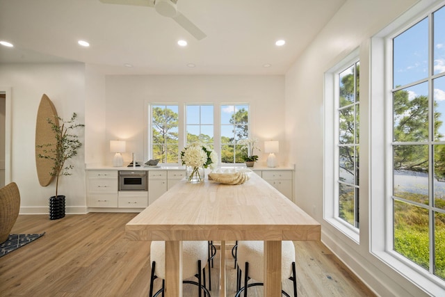 dining space with light hardwood / wood-style flooring, ceiling fan, and plenty of natural light