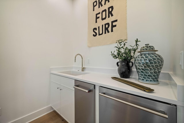 bar featuring dishwasher, white cabinets, sink, and dark hardwood / wood-style floors