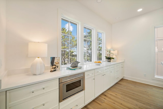 kitchen with light wood-type flooring and white cabinets